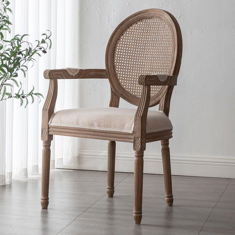 Wooden armchair with cane backrest and cushioned seat.