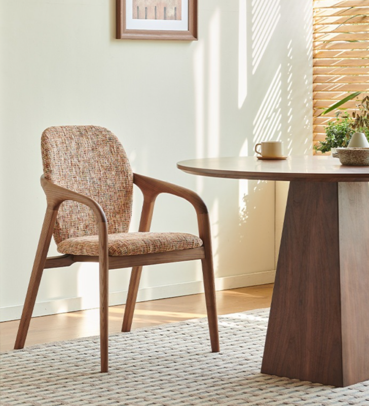 Wooden chair with woven seat beside round table.