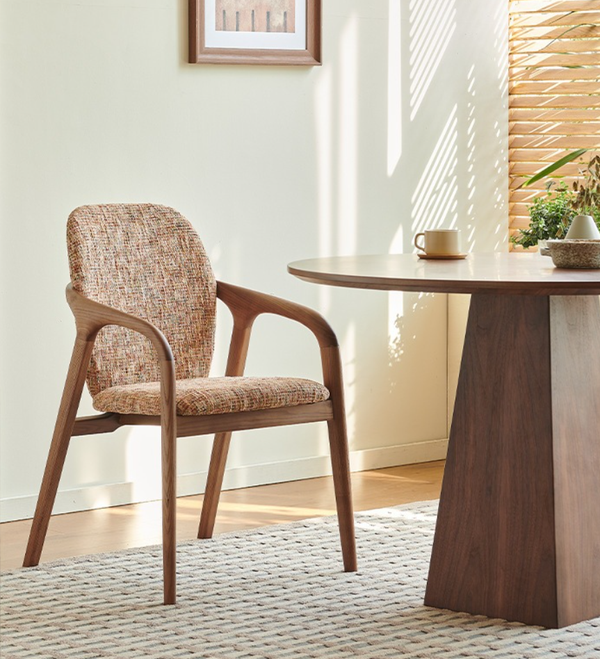 Wooden chair with woven seat beside round table.