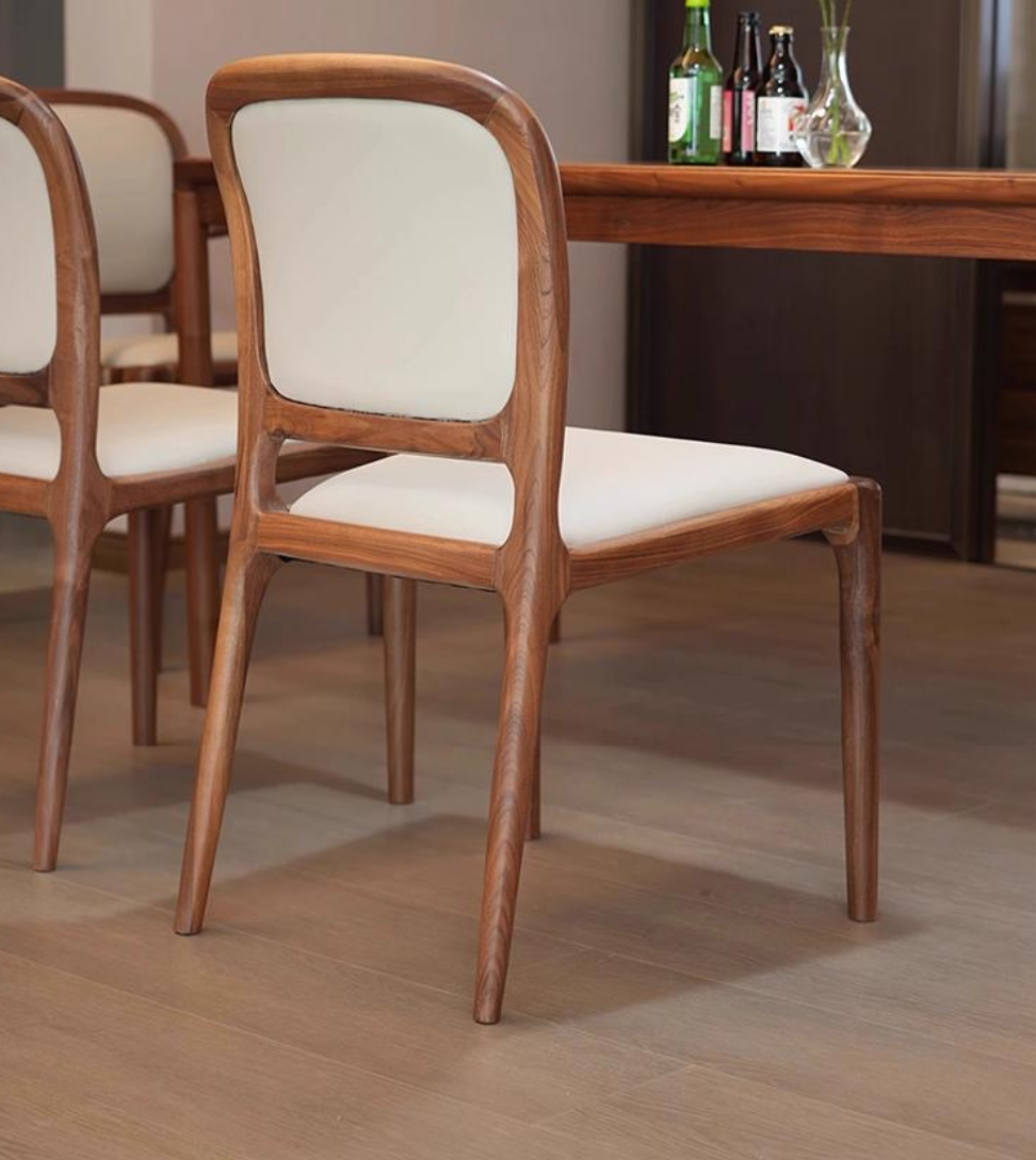 Walnut dining chair with cream upholstery and curved legs.