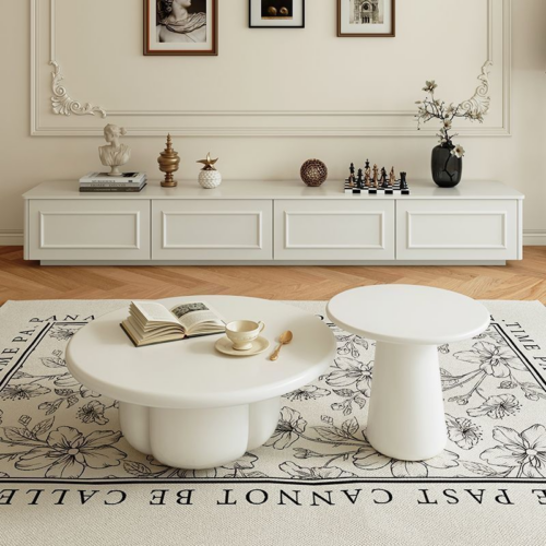 White modern coffee tables on floral rug.