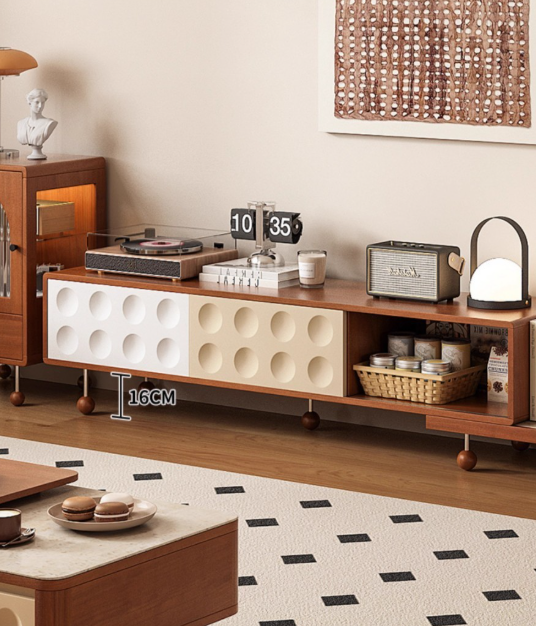 Wooden TV console with round cutouts and storage shelves.