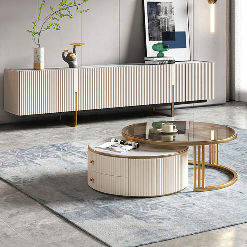 Modern round coffee table with glass top and gold legs.