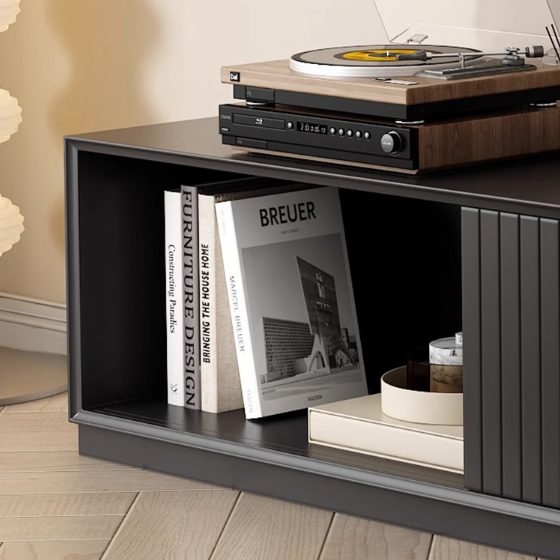 Modern black media console with vinyl player and books.