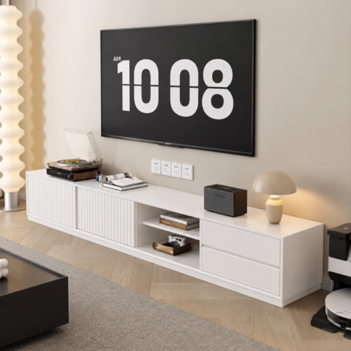 White modern TV console with storage and media items.