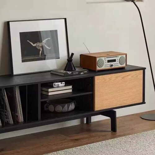 Modern black and wood media console with stereo and art.