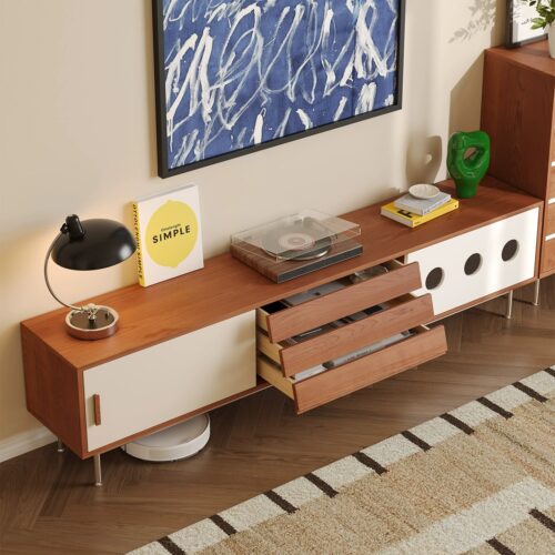 Modern wooden TV console with drawers and decor.