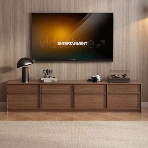 Modern wooden TV console with drawers and decorative items.