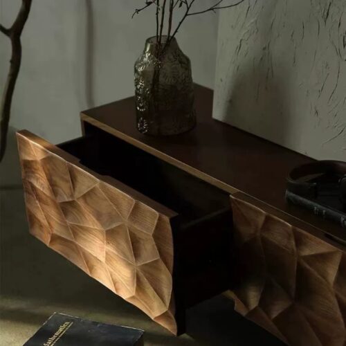 Wooden side table with carved drawer fronts and vase.