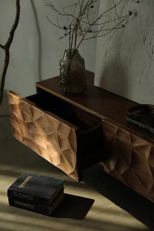 Geometric wooden side table with open drawer and books.