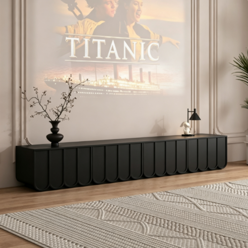 Modern black console table with curved panels under movie projection.