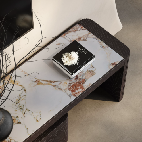 Modern marble-top side table with book and decorative branch.