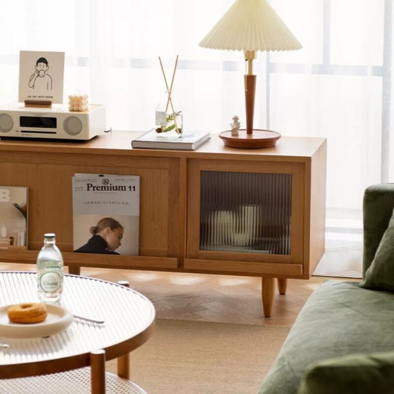 Wooden sideboard with glass panel and warm lamp.