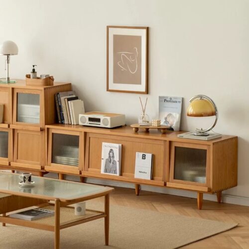 Light wood media console with glass doors and shelves.