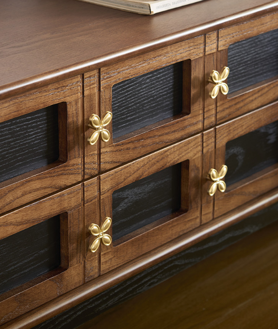 Wooden cabinet with gold butterfly handles and dark panels.