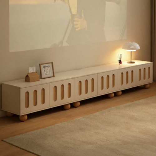 Modern beige media console with rounded cutouts and ball feet.
