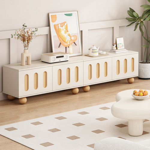 Modern white TV console with wooden accents and round legs.
