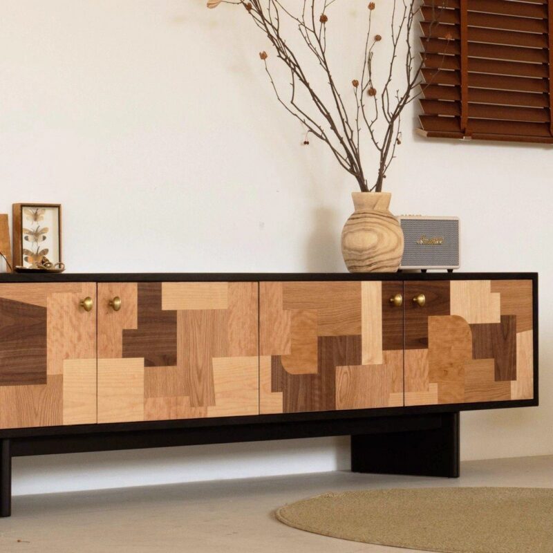 Modern wooden sideboard with geometric patterns and brass knobs.