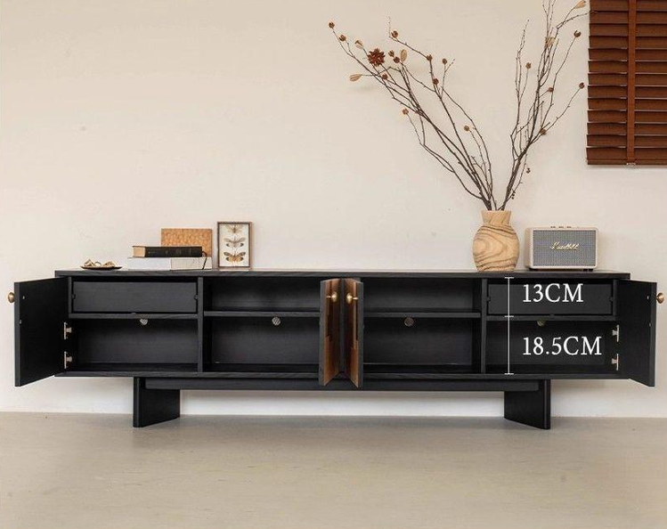 Black modern media console with open doors and decorative items.